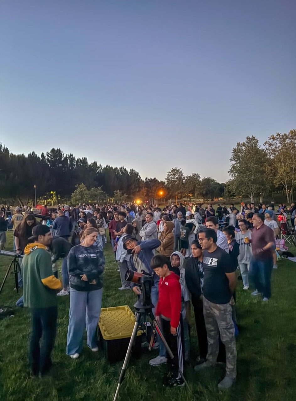 Guests viewing through a telescope at an OC Cosmic Night
